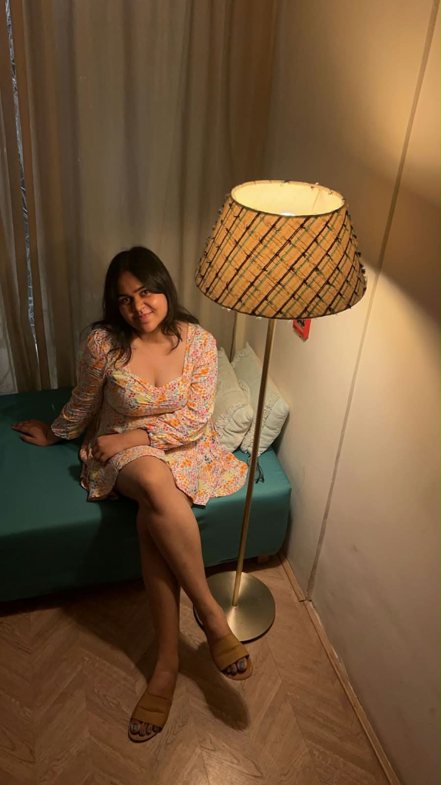 Jiya Bilthare seated beside a warmly lit floor lamp